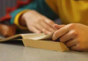 a person sitting at a table with a book