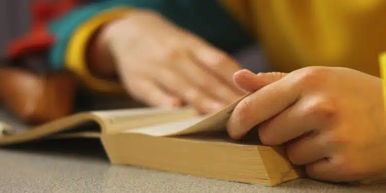 a person sitting at a table with a book