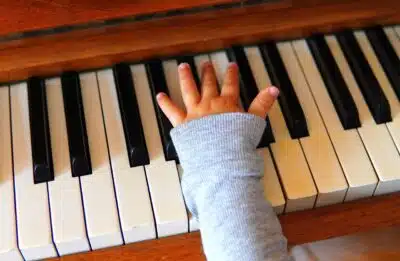 main d'enfant sur un piano