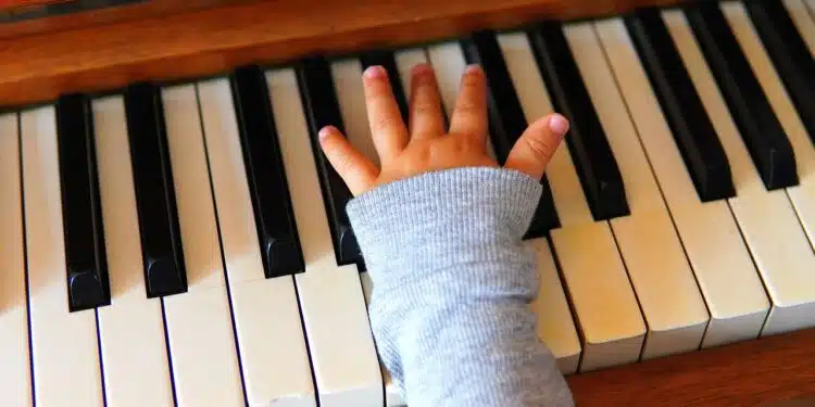 main d'enfant sur un piano